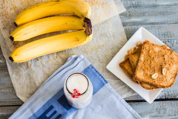 Bananen-Smoothie, Toast mit Erdnussbutter, gerösteten Erdnüssen, — Stockfoto