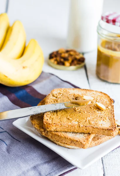 Knuspriger Toast mit Erdnussbutter, Bananen, Kaffee, Frühstück — Stockfoto