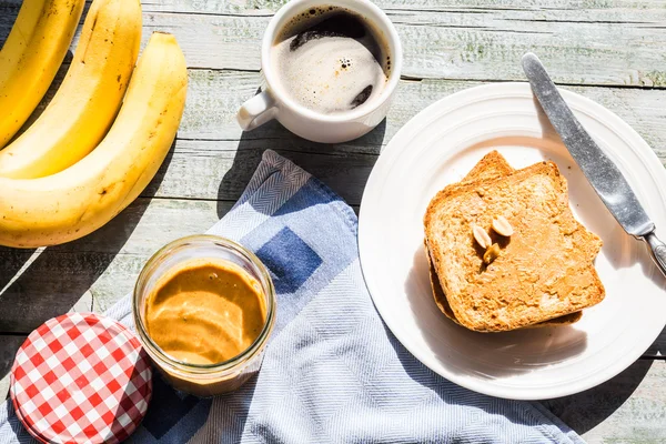 Tostadas con mantequilla de maní, plátanos frescos, café, desayuno — Foto de Stock