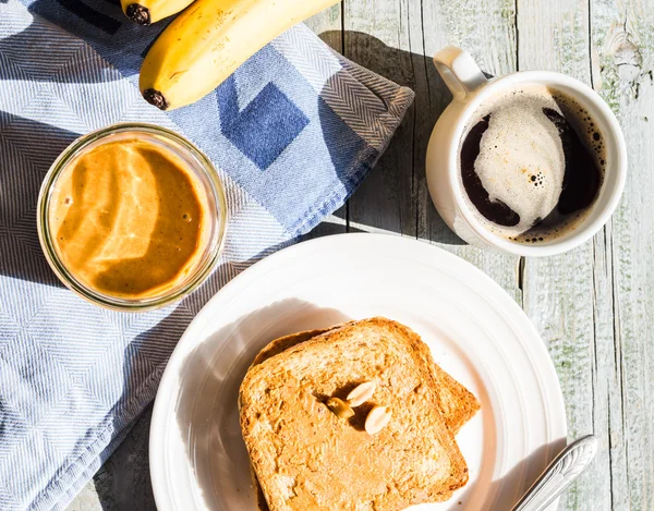 Румяный тост с арахисовым маслом, свежие бананы, кофе, завтрак — стоковое фото