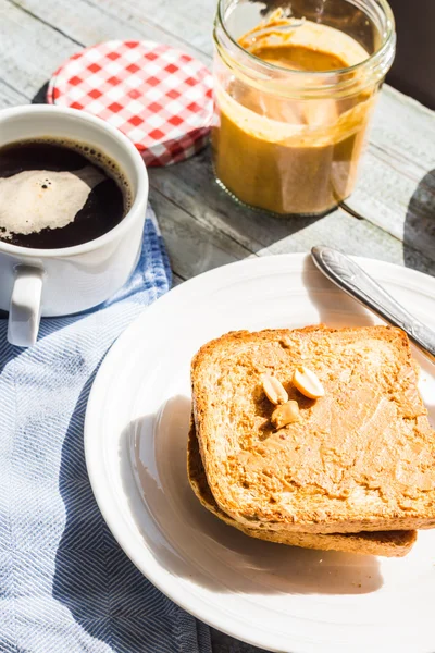 Ruddy toast with peanut butter, fresh bananas, coffee, breakfast — Stock Photo, Image