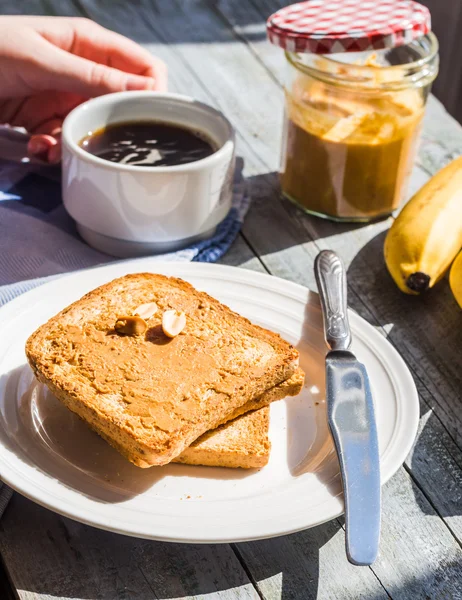 Pain grillé au beurre d'arachide, bananes fraîches, café, petit déjeuner — Photo