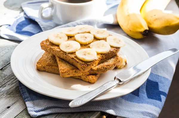 ピーナッツ バター、バナナ スライス、ミルク、朝食と血色の良いトースト ストック画像