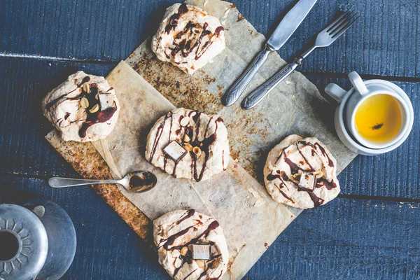 Merengue de vainilla con chocolate, cobertura de caramelo y nueces, dulce — Foto de Stock