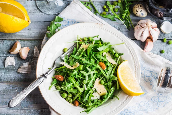 Light green salad with arugula, cheese, almonds, lemon and olive — Stock Photo, Image