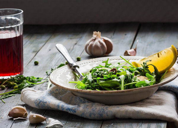 green salad with arugula, cheese, almonds, lemon, garlic