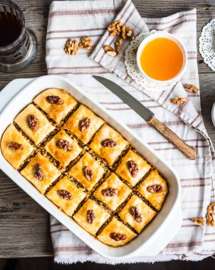 Bal ve ceviz bir woo üzerinde beyaz bir kase ile ev yapımı baklava