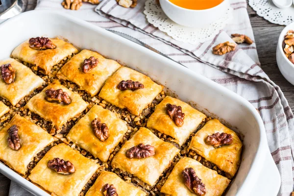 Homemade baklava with honey and walnuts in a white bow, selectiv — Stock Photo, Image