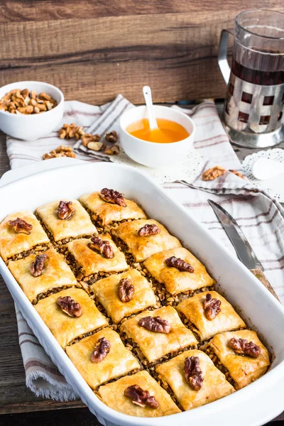 Baklava caseiro turco com mel e nozes em uma tigela branca — Fotografia de Stock