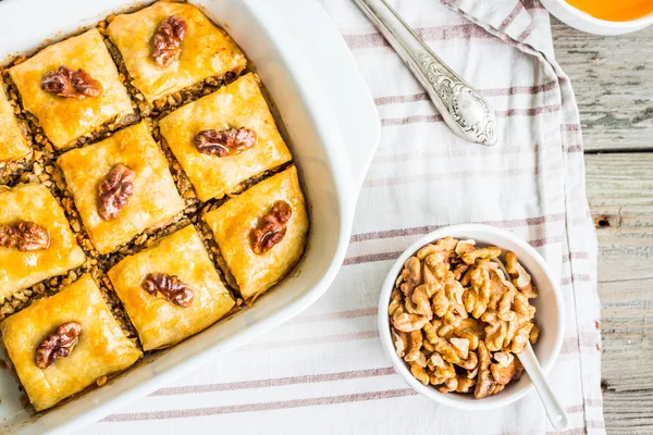 Potongan baklava dengan madu dan kacang-kacangan, pemandangan atas, pedesaan — Stok Foto