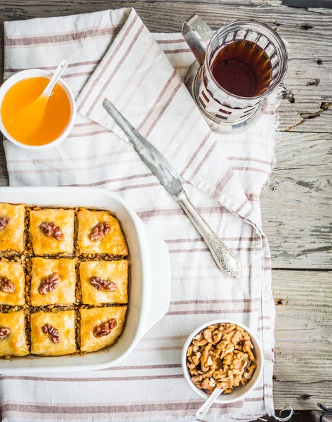 Kousky baklavy s medem a ořechy, pohled shora, rustikální — Stock fotografie