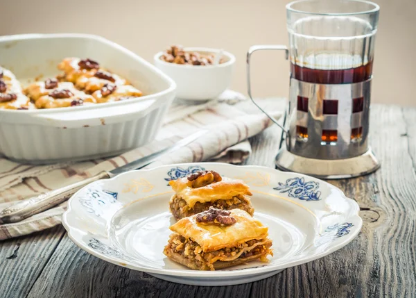 Kousky sladká baklava na desku, zelená zahrada pozadí — Stock fotografie