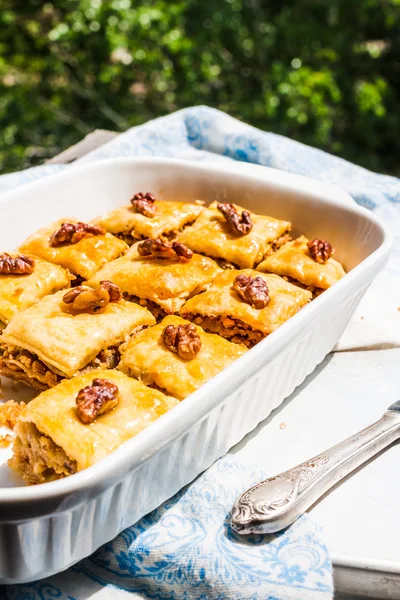 Pedaços de mel turco baklava, um fundo jardim verde — Fotografia de Stock