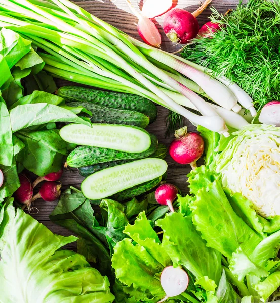 collection of raw green vegetables on rustic background, vegan