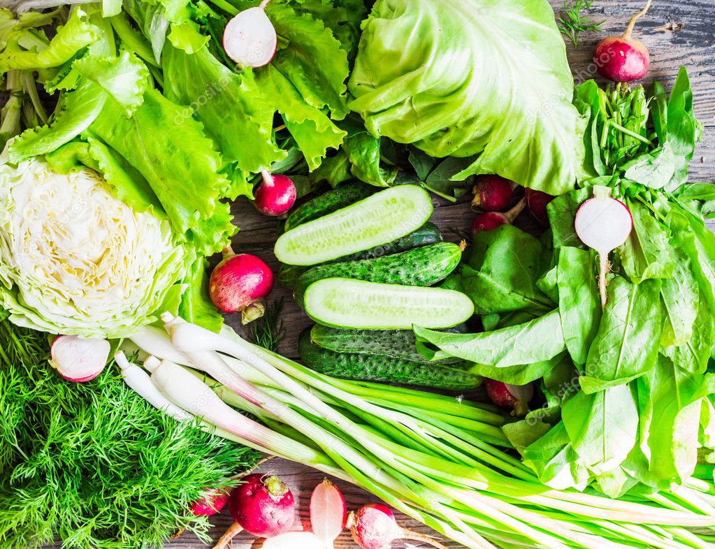 collection of raw green vegetables on rustic background, vegan