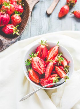 Beyaz tabak, mavi arka plan, s sulu kırmızı çilek dilimleri