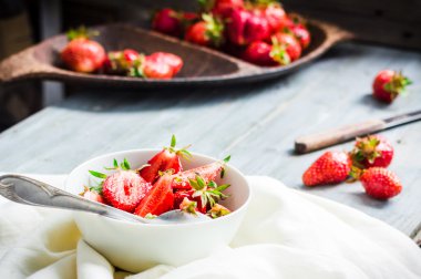 Beyaz tabak, mavi arka plan, s sulu kırmızı çilek dilimleri