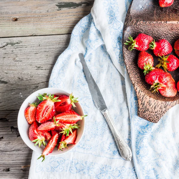 fresh red strawberry slices in a white piala, rustic background,