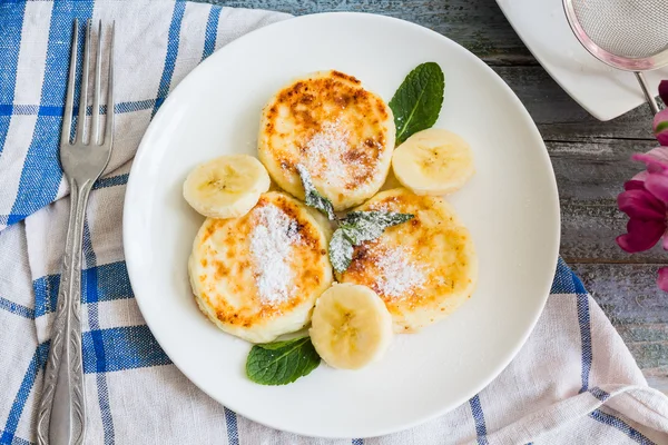 Panquecas de queijo cottage com banana, açúcar em pó e mi fresco — Fotografia de Stock