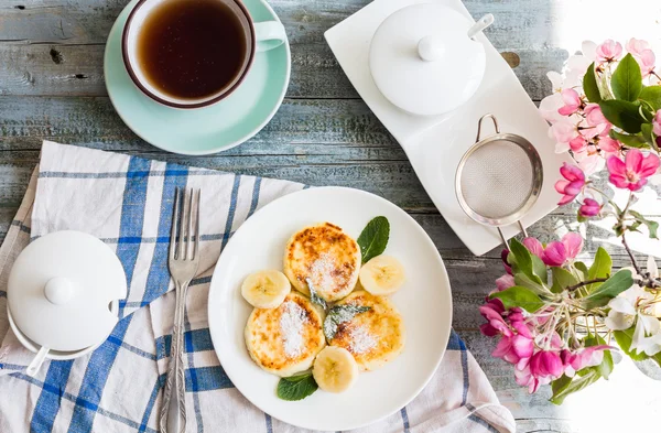 Cottage cheese pancakes with banana, powdered sugar and fresh mi — Stock Photo, Image