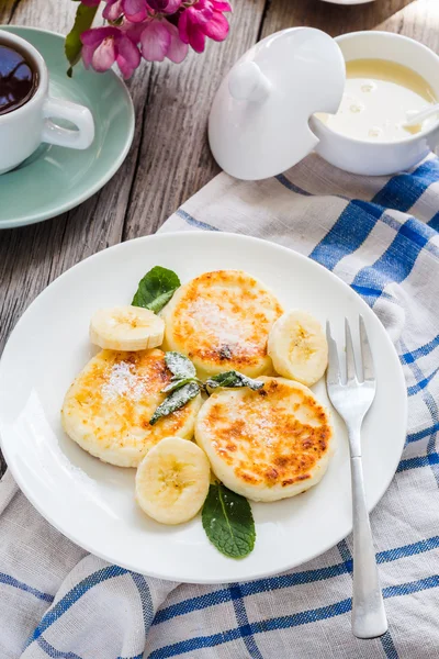 Panquecas de queijo cottage com banana, açúcar em pó e mi — Fotografia de Stock