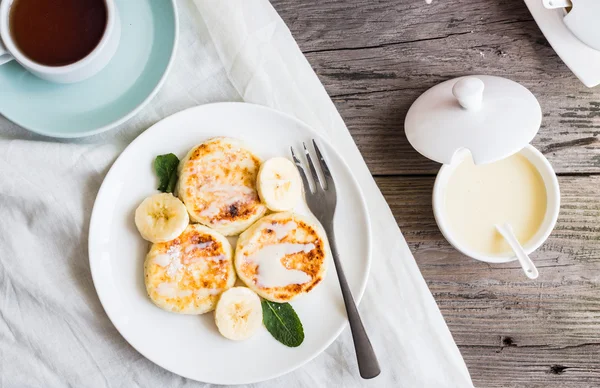 Hemmagjorda keso pannkakor med banan, kondenserad mjölk, br — Stockfoto