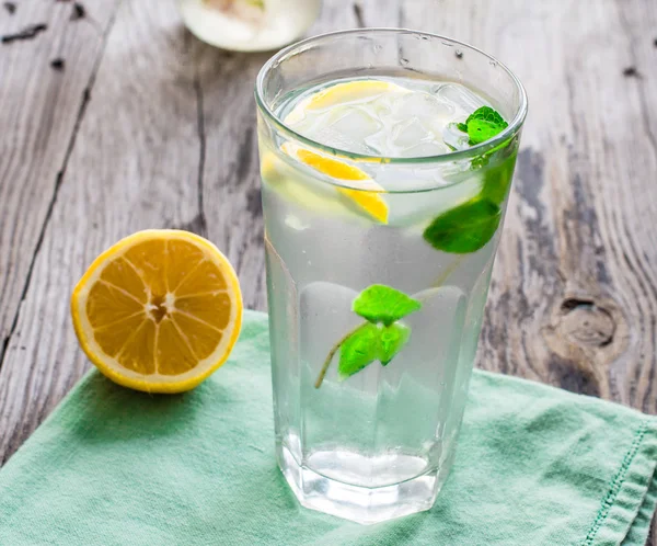 Lemonade with ice, lemon slices and fresh mint in a glass — Stockfoto