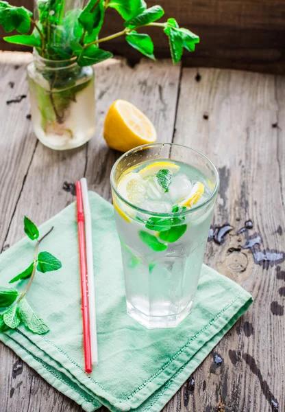 lemonade with ice, lemon slices and mint, rustic, selective focu