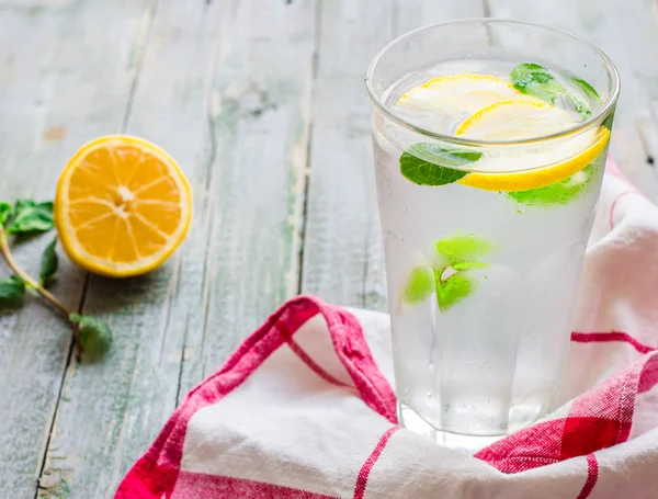 Lemonade with ice, lemon slices and fresh mint in a glass — Stockfoto