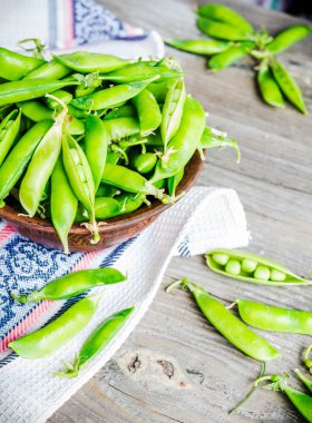 Genç yeşil bezelye pod, toprak çanak, rustik arka plan