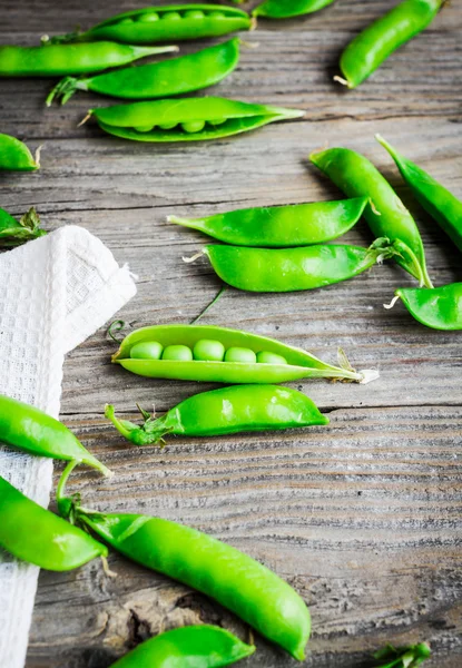 Green peas in pods young on gray wooden background, rustic, — Stock Photo, Image