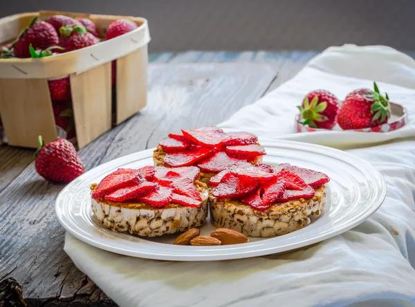 Knäckebröd med jordnötssmör och färska jordgubbar i en runda — Stockfoto