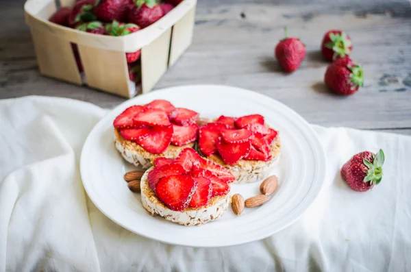 Pan crujiente con mantequilla de maní y fresas frescas, rústico, él — Foto de Stock