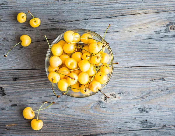 Cerises douces jaunes fraîches dans un plateau en verre, rustique, été b — Photo