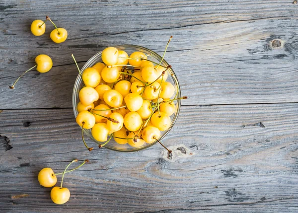 Cerezas dulces amarillas frescas en un plato de vidrio, rústico, verano b — Foto de Stock