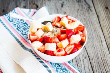 oatmeal with poppy seeds, raisins, strawberries and banana clipart