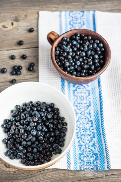 Frische Blaubeeren in einer Tonschale und einem weißen Teller, roh — Stockfoto