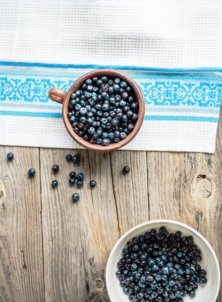 Frische Blaubeeren in einer Tonschale und einem weißen Teller, roh — Stockfoto