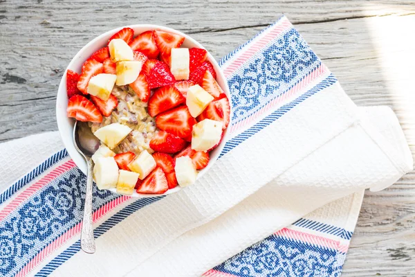 Oatmeal with poppy seeds, raisins, strawberries and banana — Stock Photo, Image