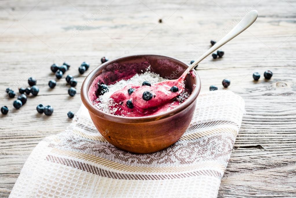 eating a banana ice cream with blueberries and coconut spoon, ha