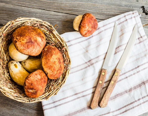 Boletus las setas sobre la tabla gris, el fondo rústico, los cuchillos — Foto de Stock