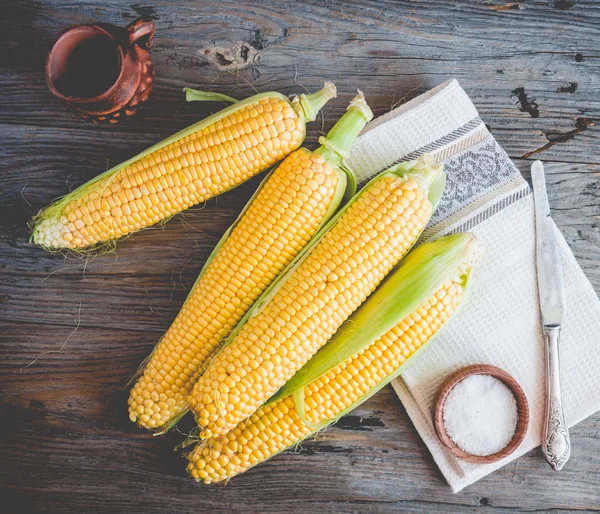 Färsk majs på majskolvar på en trä yta, hela vegetabilier, övre v — Stockfoto