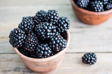 Ahşap bir masa, closeup kil tencere taze tatlı blackberry