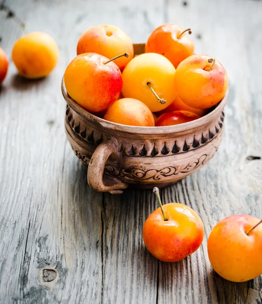 Frische gelbe Pflaumen in Keramik auf grauem Holztisch, rustikal, Bauernhof — Stockfoto