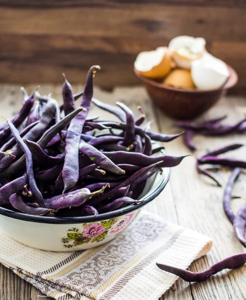 Fresh purple string beans on a gray wooden table — Stock Photo, Image