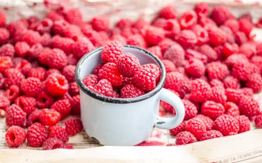 bir metal kupa ve plaser taze kırmızı ahududu