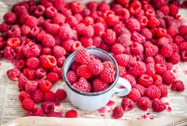 bir metal kupa ve plaser taze kırmızı ahududu