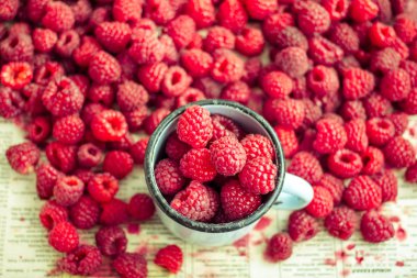 bir metal kupa ve plaser taze kırmızı ahududu