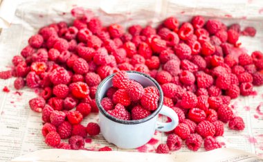 bir metal kupa ve plaser taze kırmızı ahududu