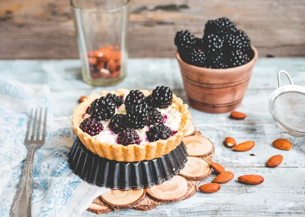 Tartlets met roomkaas en blackberry op een lichte woode — Stockfoto